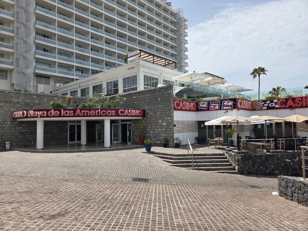Entrada al Casino Playa de las Américas en Tenerife, con cartel iluminado y edificio moderno de fondo.