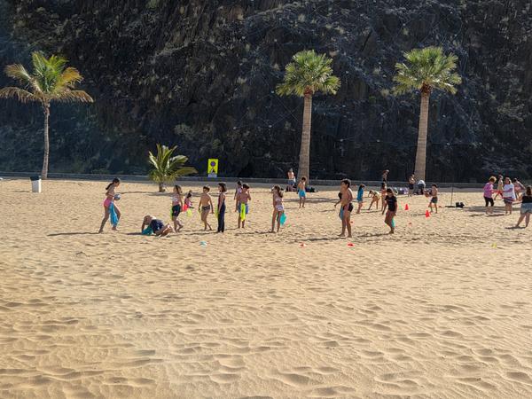 Niños en Las Teresitas Grupo de niños jugando en la arena de la Playa de Las Teresitas en un día soleado.