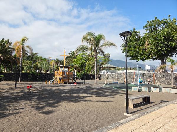 Parque en Playa Jardín Parque infantil con temática de barco en Playa Jardín, Puerto de la Cruz, con palmeras y fondo de montaña.