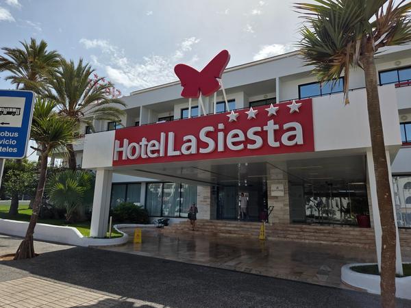 Hotel La Siesta en Tenerife Fachada del Hotel La Siesta con letras rojas y una mariposa, ubicado en Tenerife.