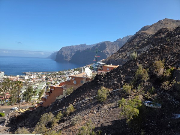 Vista panorámica de Los Gigantes desde un mirador en la ladera, con el acantilado, el mar y parte del pueblo al fondo.