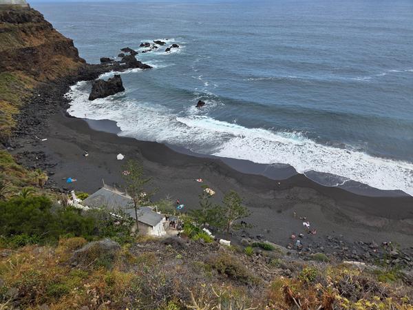 Playa El Bollullo en Tenerife Vista panorámica de la Playa El Bollullo con arena negra volcánica y oleaje del Atlántico.