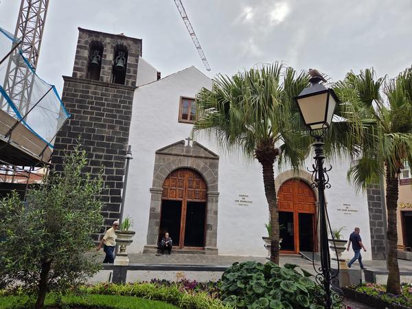 Iglesia antigua en Puerto de la Cruz Fachada de iglesia histórica con campanario de piedra y palmeras en Puerto de la Cruz, Tenerife.