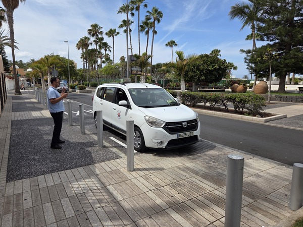 Servicio de transporte en taxi en Costa Adeje, ideal para moverse por el sur de Tenerife Taxi blanco estacionado junto al paseo marítimo en Costa Adeje, Tenerife